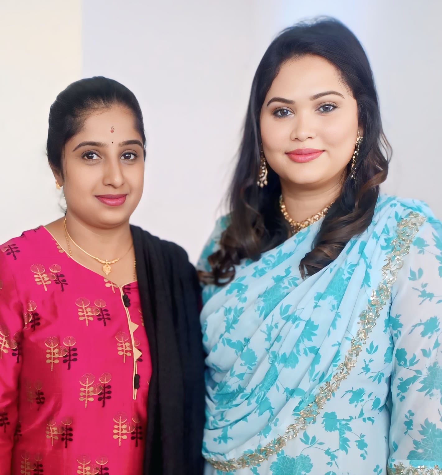 Anitha with a client draped in a teal floral saree